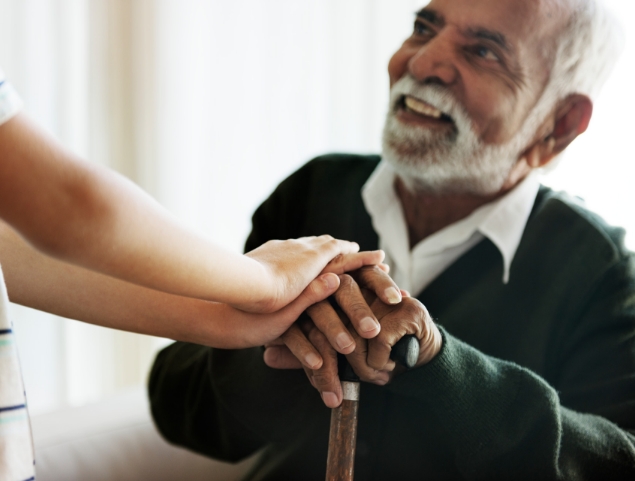 senior man smiles up at his caregiver