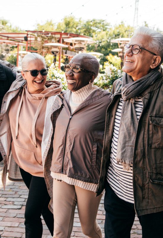 well-dressed group of senior friends walk around a scenic downtown district