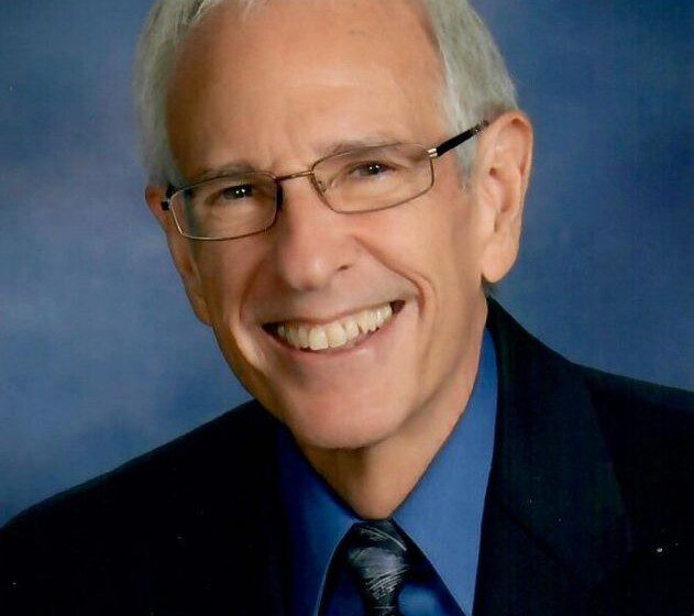 Headshot of Dave Humphreys, smiling and wearing a black suit with blue shirt