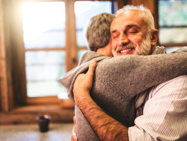 two seniors embrace in a hug