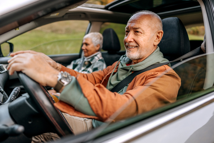 senior man and his wife take a leisurely drive on a sunny day