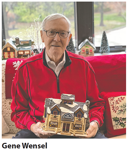 senior man with glasses sits posed on a red couch holding a porcelain Christmas decoration