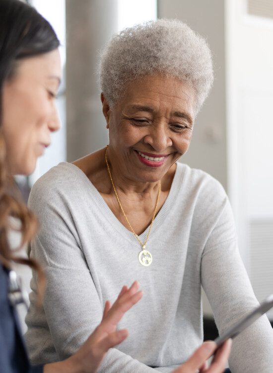 senior woman is shown information by her caretaker while seated