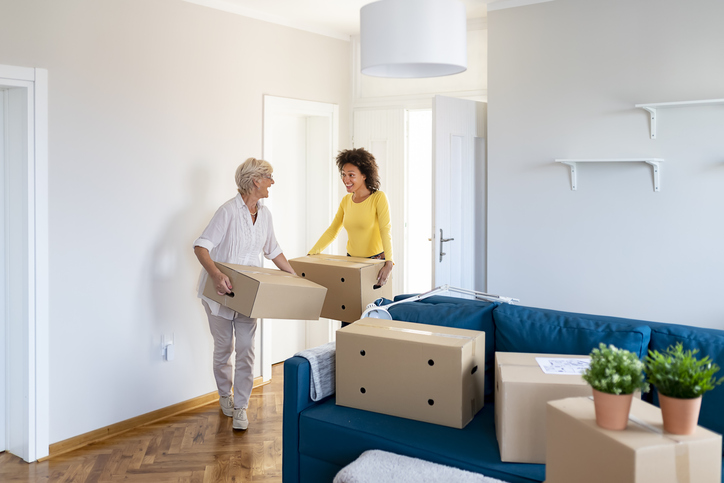 senior woman is helped by her adult daughter while packing to move to a senior community